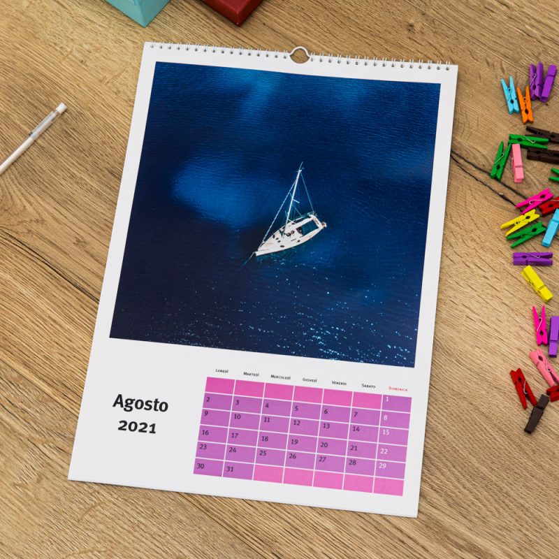 Calendario personalizzato con foto con giorni in rosa steso su tavolo in legno
