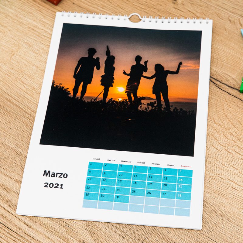 un calendario personalizzato con foto steso su un tavolo di legno